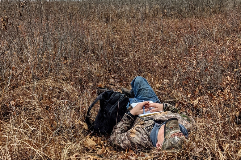 Student laying in grass